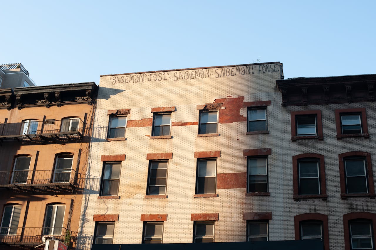 A classic urban apartment building exterior with brick facade and windows.
